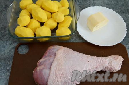 Подготовить продукты для приготовления голени индейки с картошкой в духовке. Картофель очистить от кожуры и промыть. Сливочное масло заранее достать из холодильника, чтобы оно было комнатной температуры. Голень индейки вымыть и обсушить.