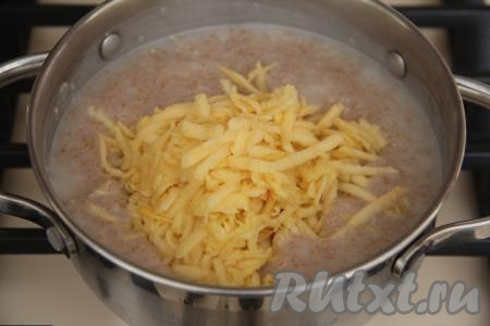 Пшеничная каша станет средней густоты. Яблоко очистить от кожуры, натереть на крупной тёрке и добавить в кашу, тщательно перемешать, довести до кипения и убрать с огня. Накрыть кастрюлю с кашей крышкой, тщательно укутать в тёплое полотенце и дать настояться в течение 10 минут.
