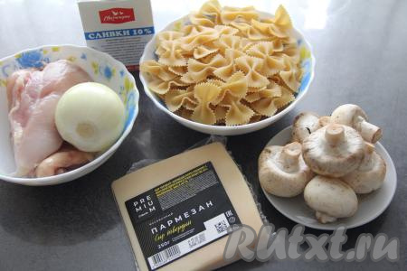 Подготовить продукты для приготовления макаронов с курицей и шампиньонами в сливочном соусе. Шампиньоны промыть водой, нарезать на пластинки. Лук и чеснок почистить. Куриное филе промыть и обсушить.