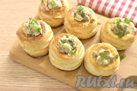 Остывшие волованы из слоёного теста наполняем тёплой грибной начинкой, посыпаем нарезанным зелёным луком (или другой зеленью) и сразу подаём к столу. Можно их подать и полностью остывшими.