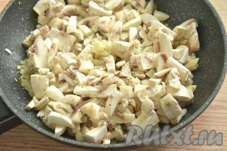 Промытые и обсушенные шампиньоны нарезаем на небольшие кусочки, добавляем к обжаренному луку, сюда же выкладываем пропущенный через пресс зубчик чеснока, по вкусу солим и перчим, перемешиваем. Жарим грибы с луком минут 10, время от времени помешивая.