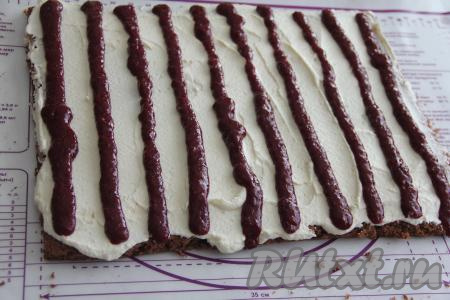 Остывший корж снять с пергамента и смазать крем-чизом. Вишнёвую начинку выложить в кулинарный мешок и отсадить в виде полосок поверх крема, как на фото.