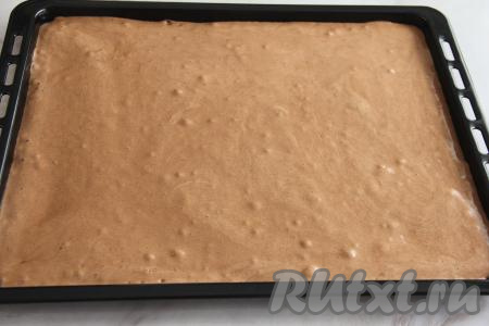 Застелить противень (у меня размер противня 50х40 сантиметров) пергаментной бумагой (или ковриком) для выпечки, выложить тесто и разровнять. Поставить противень в духовку, разогретую до 180 градусов.