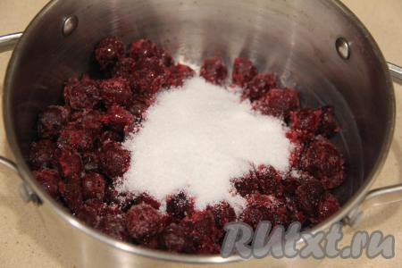 Прежде всего подготовим вишнёвую начинку. Для начинки подойдёт и свежая, и замороженная вишня без косточек. Вишню выложить в кастрюлю (если ягоды заморожены, размораживать их не нужно), добавить сахар, перемешать, довести ягоды до кипения на среднем огне, а после этого варить на небольшом огне 2-3 минуты (сахар должен полностью раствориться), периодически перемешивая вишнёвую начинку.