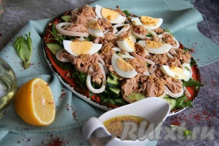 Яйца нарезать на крупные дольки и выложить поверх салата.