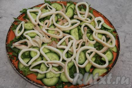 Кальмары нарезать кружочками и выложить сверху овощей.