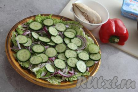 Следующим слоем выложить огурец, нарезанный на тонкие кружочки. Поверх огурчиков разложить куриное мясо, нарезанное на кубики, и болгарский перец, нарезанный на тонкие полоски.