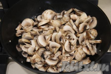 Промытые шампиньоны нарезать на пластинки (если вы готовите пирог с отваренными лесными грибами, тогда нарежьте их достаточно мелко), выложить в сковороду с растительным маслом и обжарить, иногда перемешивая, на среднем огне до готовности (в течение 15 минут), посолить, убрать с огня, дать грибочками остыть.
