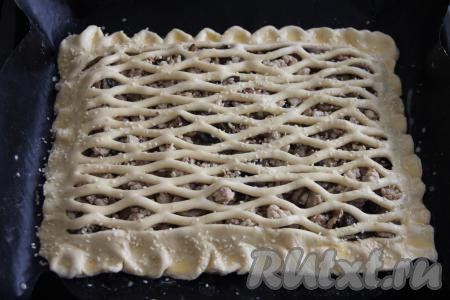 Смазать тесто взбитым желтком, по желанию, посыпать пирог кунжутом и поставить в разогретую духовку.