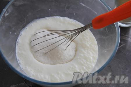 В запенившуюся смесь кефира и соды всыпать сахар, перемешать венчиком.