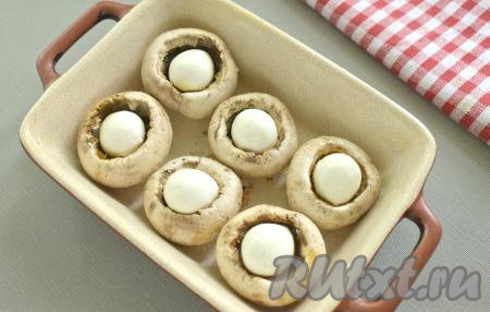 Форму для запекания смазываем растительным маслом. Выкладываем шампиньоны с моцареллой.