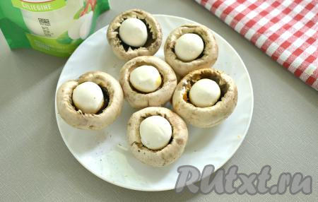 Затем помещаем в каждую шляпку по шарику моцареллы.