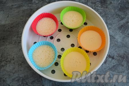 В поддон для варки на пару (такой поддон входит в комплект любой мультиварки) поставить 5 силиконовых формочек для приготовления маффинов. Формочки я маслом не смазывала, но, при желании, можно их немного смазать сливочным маслом. Яйца, взбитые с молоком, разлить по формочкам, заполняя их на половину объёма.