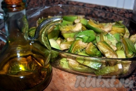 Сложить артишоки в форму для запекания, добавить оливковое масло, соль, перец, перемешать и отправить в духовку с температурой 180 градусов.