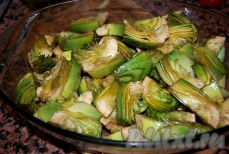 Сложить артишоки в форму для запекания, добавить оливковое масло, соль, перец, перемешать и отправить в духовку с температурой 180 градусов.