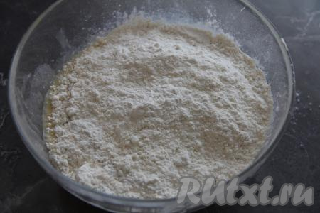 Частями всыпать просеянную муку, каждый раз очень хорошо вмешивая её в дрожжевое тесто. Вначале, добавляя муку, нужно перемешивать тесто ложкой, а затем, подсыпая муку только по мере необходимости, вымесить тесто руками в течение 7-8 минут.