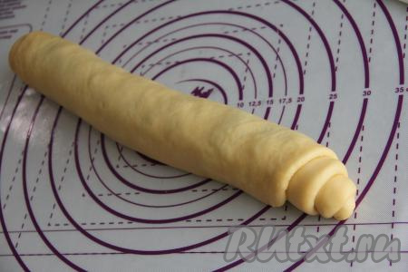 Свернуть тесто с шоколадной начинкой в плотный рулет, начиная с широкого края.