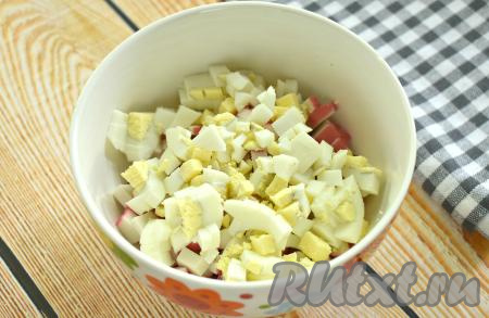 В эту же миску добавляем яйца, нарезанные на небольшие кусочки.