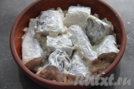 Очень хорошо перемешать кусочки рыбы с луком, майонезом и чесноком, покрывая навагу майонезом со всех сторон. Выложить навагу в жаропрочную форму и поставить в разогретую духовку.