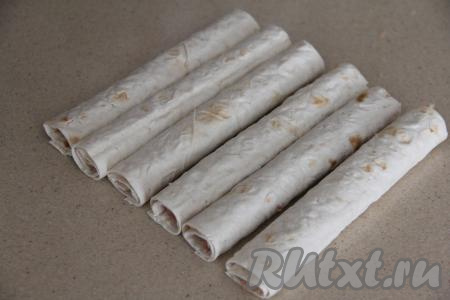 Свернуть лаваш с фаршем в плотный рулетик, начиная со стороны с начинкой. Таким образом сформировать все 6 трубочек с фаршем.