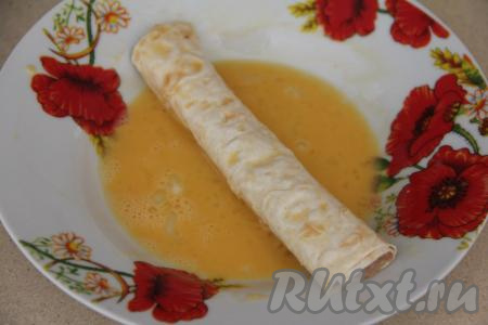 В тарелку разбить яйцо, взбить его вилкой до получения однородной массы. Трубочки из лаваша с фаршем обмакнуть со всех сторон во взбитое яйцо.