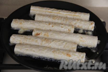 В сковороду влить немного масла, разогреть его хорошо и выложить трубочки в один слой.