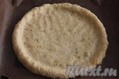 Противень застелить ковриком (или пергаментом) для выпечки, выложить картофельное тесто и сформировать круг с бортиком диаметром примерно 28 сантиметров.