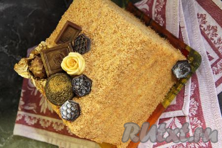 Обрезки перетереть в крошку и обсыпать ими верх и бока торта. Готовый медовик поставить в холодильник на ночь для пропитки. Я дополнительно украсила торт шоколадными конфетами перед подачей.