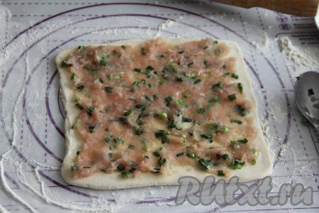 Вначале на один раскатанный пласт теста, немного отступив от краёв, равномерно выложить половину начинки.