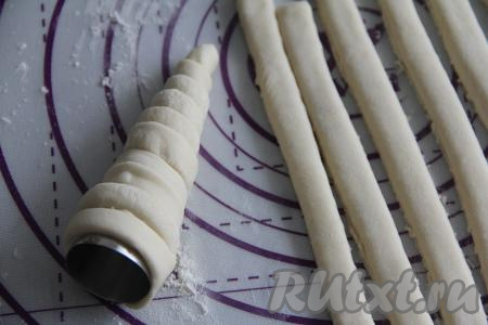 Сформировать трубочки можно на металлических конусах (я покупала конусы в магазине для кондитеров). Если нет таких конусов, можно сделать конусы из фольги. Я предварительно смазала конусы растительным маслом. Обернуть металлические конусы полосками слоёного теста, формируя трубочки. 