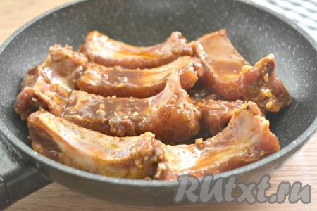 Разогреваем сковороду, выкладываем замаринованные рёбрышки (маслом сковороду не смазываем, так как оно входит в состав маринада). Оставшийся маринад тоже выливаем на сковороду.