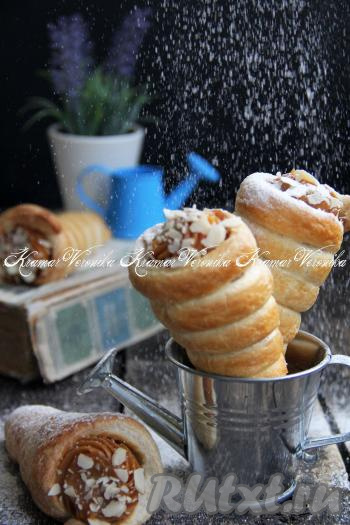 Аппетитные, очень вкусные трубочки из слоёного теста, приготовленные с варёной сгущёнкой, по желанию, посыпать сахарной пудрой (можно украсить ещё миндальными лепестками) и подать к чаю или кофе.