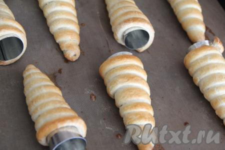 Выпекать трубочки в разогретой духовке минут 25 (до золотистого цвета) при температуре 200 градусов. Затем достать из духовки, слегка остудить и снять трубочки с конусов.