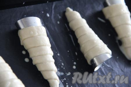 Яичным желтком, слегка взбитым вилкой, смазать заготовки трубочек.