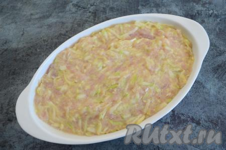 Подходящую по размеру форму для запекания смазать растительным маслом и выложить в неё массу из кабачков, яиц, сыра и индейки.