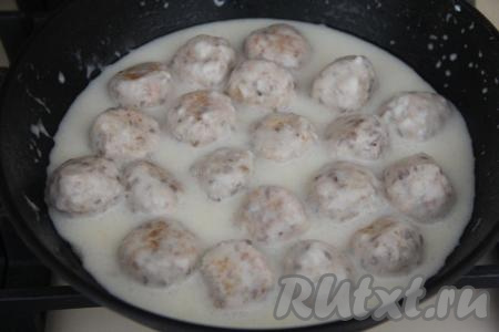 В небольшой ёмкости соединить 200 миллилитров воды комнатной температуры и сметану, перемешать, посолить получившийся сметанный соус по вкусу. Сметанный соус вылить в сковороду с тефтелями. После того как соус закипит, накрыв сковороду крышкой, тушить куриные тефтели из фарша и гречки на небольшом огне минут 15. В процессе тушения тефтельки несколько раз можно перевернуть с бока на бок, чтобы они равномерно пропитались соусом.