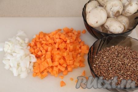 Подготовить продукты для приготовления гречки с грибами на сковороде. Лук и морковь почистить. Лук мелко нарезать. Морковь нарезать на маленькие кубики (или натереть на крупной тёрке). Шампиньоны промыть водой, нарезать на пластины. Вместо шампиньонов можно взять лесные грибы, предварительно отваренные в течение 25-30 минут с момента закипания воды, затем лишнюю воду нужно будет слить, дать остыть грибочкам, а после этого нарезать их на части. Если же будете готовить со свежими вешенками, тогда промойте их водой и нарежьте. Гречку, если необходимо, перебрать, а затем выложить в сито и тщательно промыть водой, дать стечь лишней воде.