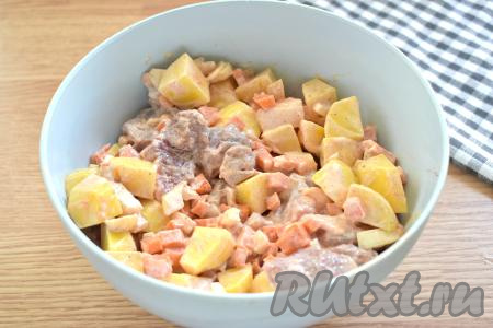 Хорошо перемешиваем свинину с овощами, покрывая сметаной со всех сторон и равномерно распределяя специи.