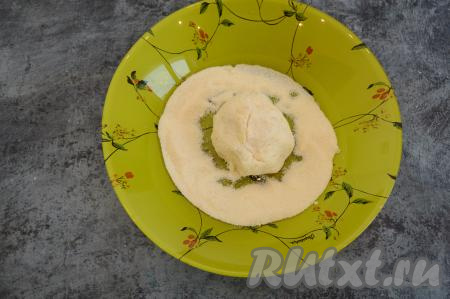 Зрительно разделить творожно-банановое тесто на 4 части (мы будем формировать 4 сырника). На тарелку насыпать 1-2 столовых ложки манки. Влажными руками из части теста сформировать округлый сырник и обвалять его в манке со всех сторон. Аналогично сформировать и обвалять в манке все сырники.