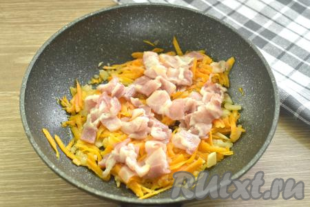 Полоски сырокопчёного бекона нарезаем на кусочки и добавляем на сковороду с обжаренными овощами, перемешиваем. Обжариваем 2-3 минуты, время от времени помешивая.