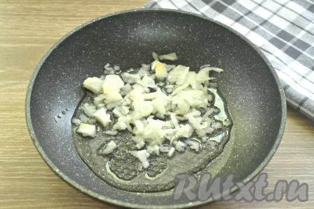 Гречневую крупу перебираем, убирая испорченные зёрнышки, после этого перекладываем в сито, тщательно промываем водой, оставляем на несколько минут, чтобы слились остатки воды. Очищаем репчатый лук, зубчик чеснока и морковку. Мелко нарезаем луковицу. Чеснок пропускаем через пресс. На сковороду вливаем растительное масло, разогреваем его на среднем огне, после этого выкладываем лук и чеснок, обжариваем 2 минуты, периодически перемешиваем.