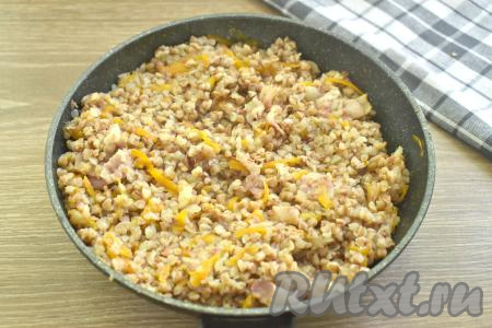 Как только вода закипит, убавляем огонь до минимума. Сковороду накрываем крышкой. Варим гречневую кашу с беконом на сковороде 20 минут (до испарения воды).