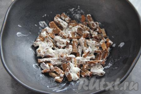 Штук 15 сухариков оставить для украшения. Остальные сухарики всыпать в салатник, добавить 1 столовую ложку майонеза. Перемешать сухарики с майонезом.