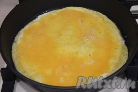 Влить яичную массу и аккуратно распределить по тортилье. Готовить тортилью с яйцом на среднем огне примерно 1 минуту.