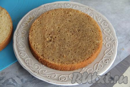 На плоскую тарелку выложить бисквитный корж и пропитать его частью кофейной пропитки. Аналогично пропитать ещё два коржа.