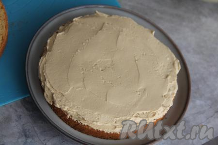 Смазать первый пропитанный корж частью крема, выложить второй пропитанный корж, тоже смазать его частью крема и накрыть третьим коржом. 