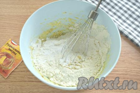 Затем всыпаем разрыхлитель, частями просеиваем муку, каждый раз тщательно вмешивая её столовой ложкой.