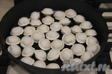 В сковороду с высоким бортиком влить растительное масло и поставить на огонь. Как только сковорода с маслом хорошо разогреется, выложить замороженные пельмени в один слой.