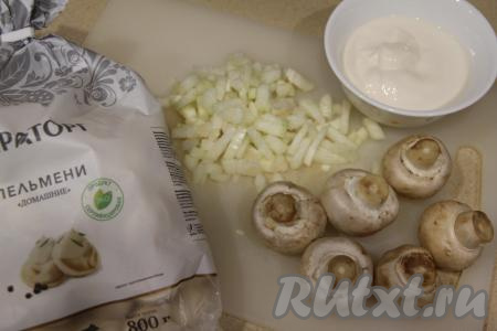 Подготовить продукты для приготовления пельменей с грибами и сметаной на сковороде. Пельмени размораживать не нужно. Лук почистить и мелко нарезать. Промыть водой шампиньоны, убирая загрязнения с грибов.
