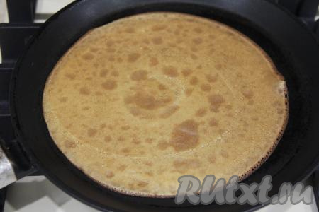 Жарить блин с двух сторон до золотистого цвета (ориентировочно по 1-2 минуте с каждой стороны), затем переложить на тарелку. Периодически перемешивая блинное тесто в миске, постепенно пожарить все блинчики (у меня получилось 12 штук), складывая их горкой на тарелку.